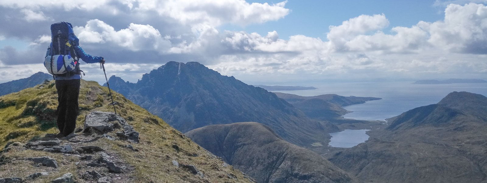 Meline hiking on a ridge of a tall mountain in Isle of Skye that is similar to Norway's landskape