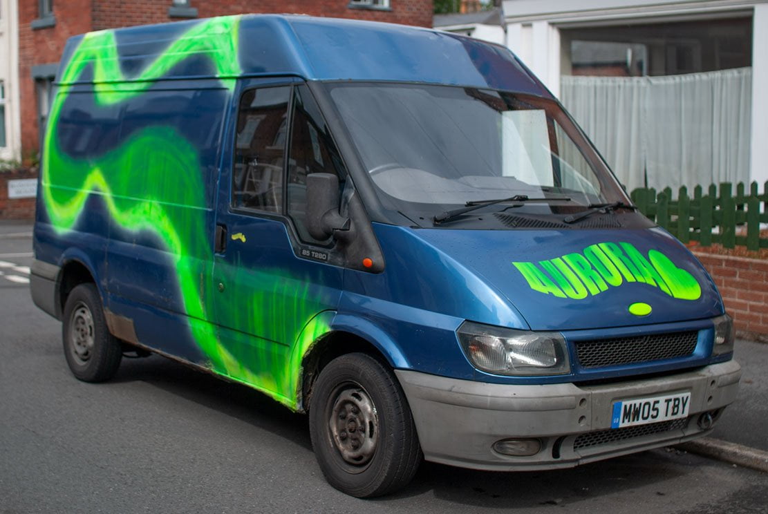 a blue ford transit van called Aurora with an Aurora wavy logo on the front bonet