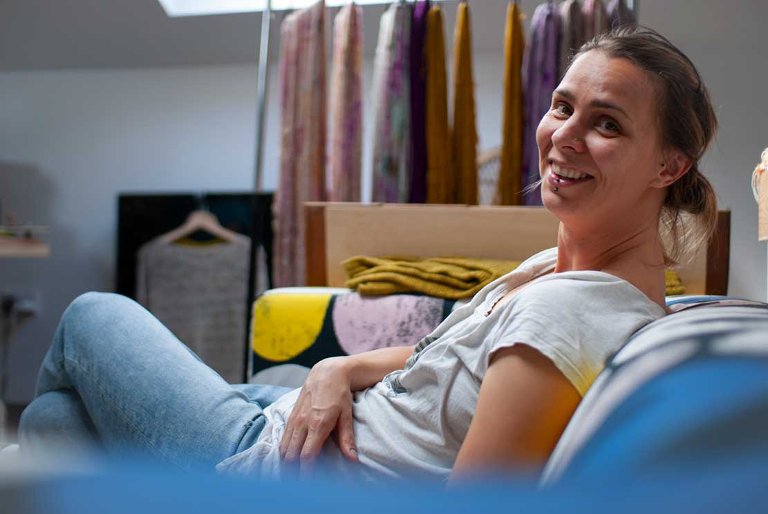 our friend Petra sitting comfortably on a sofa in her yarn studio