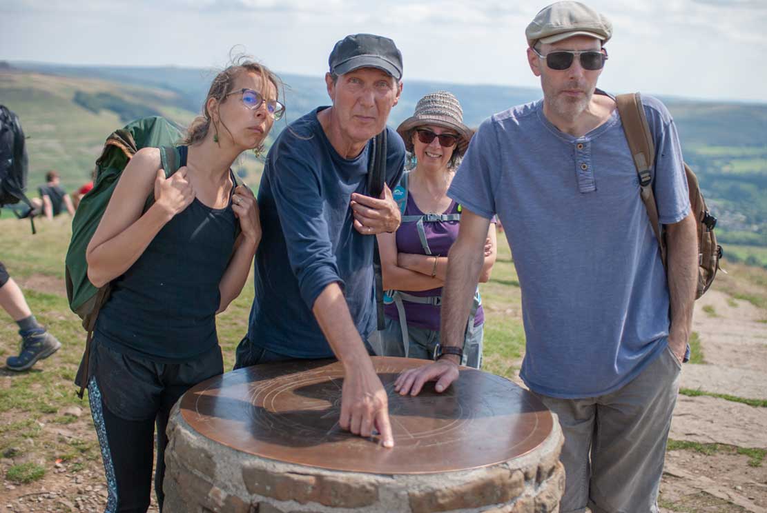 4 of us on the top of a hill. Gary is pointing to a map telling us the names of the surrounding hills.