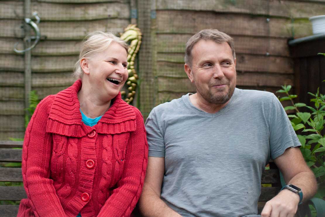 Katka and Kevin sitting and smiling in their garden